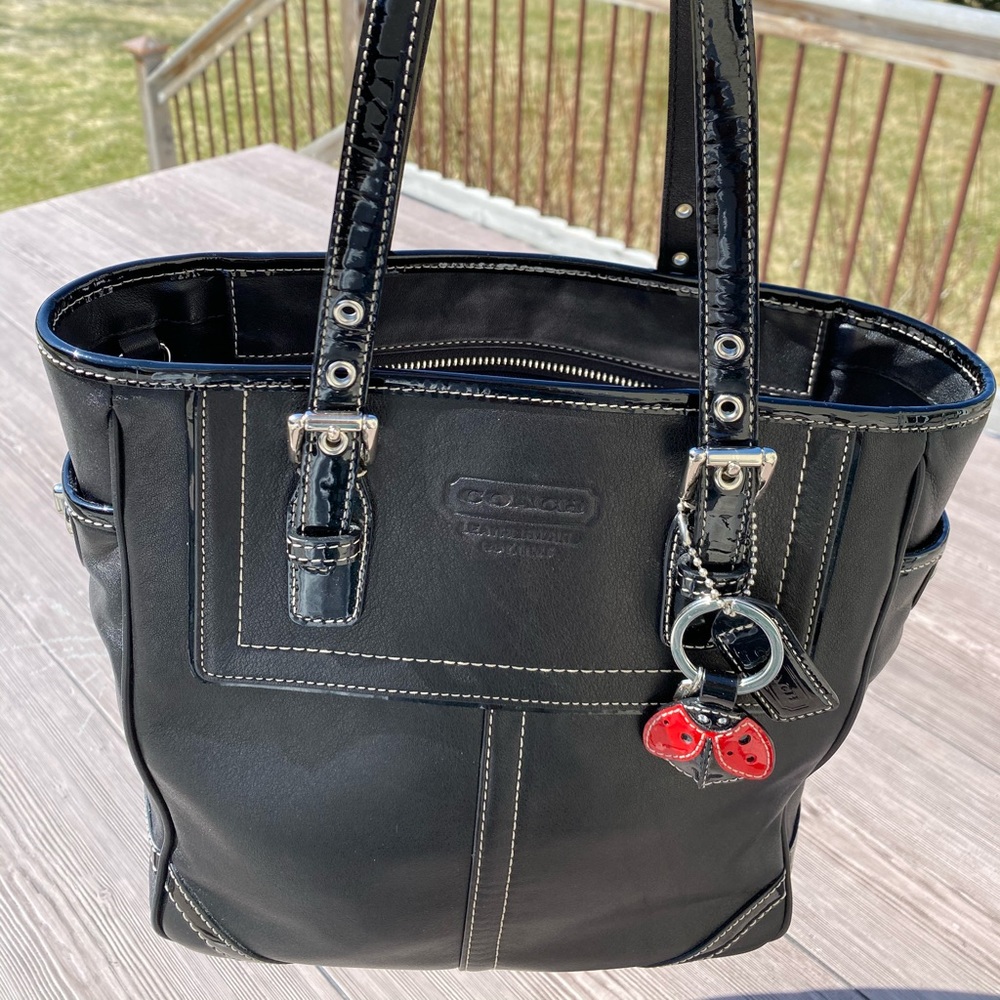 Coach black tote with ladybug keychain.